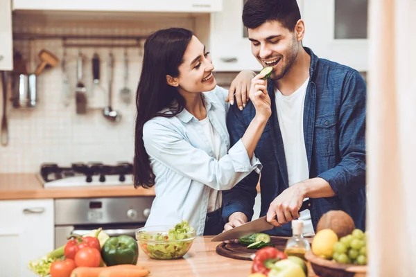 Pasangan muda yang menyenangkan menyiapkan salad bersama-sama di rumah — Stok Foto