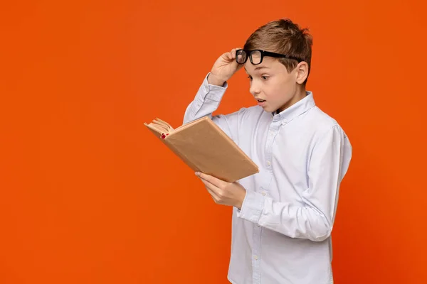 Känslomässig tonåring läser spännande bok, höja sina glasögon — Stockfoto