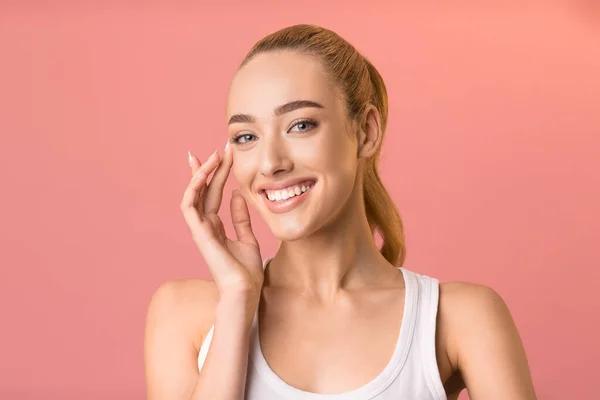 Joven dama posando tocando la piel suave sonriendo en el estudio — Foto de Stock