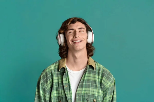 Portret van koele tiener in headset ontspannen om zijn favoriete muziek op kleur achtergrond — Stockfoto