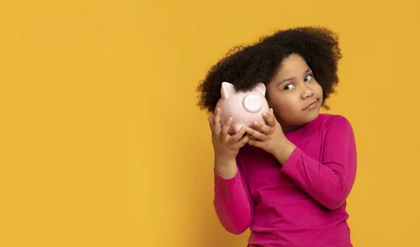 Retrato de niña africana pensativa con alcancía en las manos — Foto de Stock