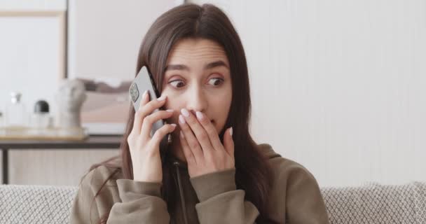 Здивована дівчина отримує приємні новини по телефону — стокове відео