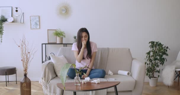 Giovane donna che tossisce e soffia il naso a casa — Video Stock