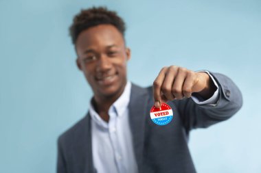 Afro-Amerikan iş adamının elindeki vatansever kampanya düğmesini kapat.