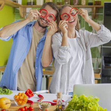 Romantik ve komik çift salata yaparken birlikte eğleniyorlar.
