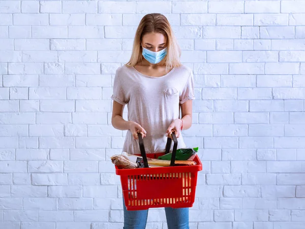 Vrouw met beschermend masker kijkt in mand — Stockfoto