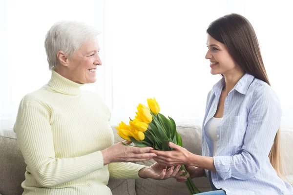 Dia das mulheres. Filha dando buquê de tulipas à mãe — Fotografia de Stock