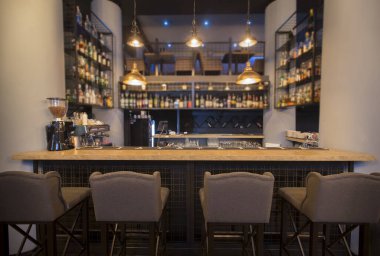 Ahşap tezgah ve sandalyeli modern bir kafe.