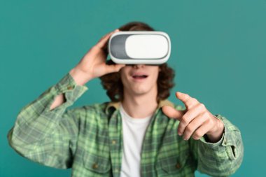 Sanal gerçeklik. VR kulaklıklı genç renk arkaplanında online oyunlar oynuyor
