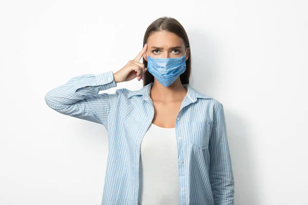 Vrouw dragen beschermende masker poseren in studio over witte achtergrond — Stockfoto