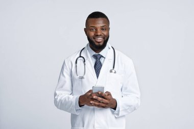 Cep telefonu tutan mutlu Afrikalı doktor, beyaz arka plan