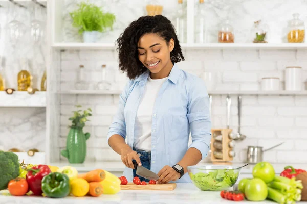 Vacker ung afro kvinna förbereder grönsakssallad — Stockfoto
