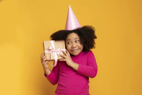 Überraschungsgeschenk. Niedliche kleine afroamerikanische Geburtstagskind Schütteln Geschenk Box — Stockfoto