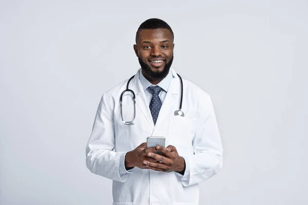 快乐的非洲医生，手持手机，白人背景 — 图库照片