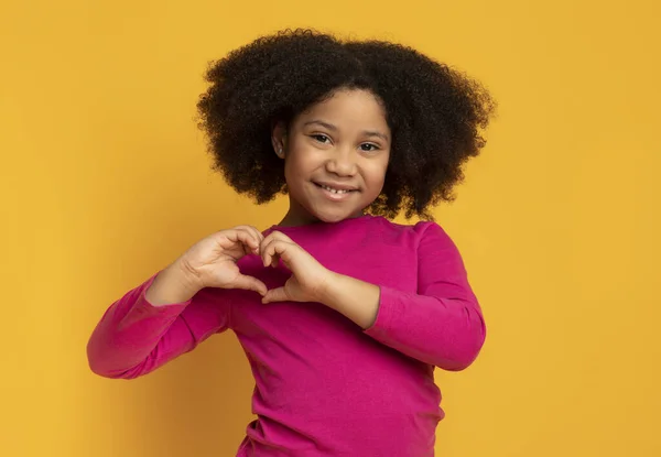 Schattig weinig afrikaans amerikaans meisje maken hart vorm met haar handen — Stockfoto