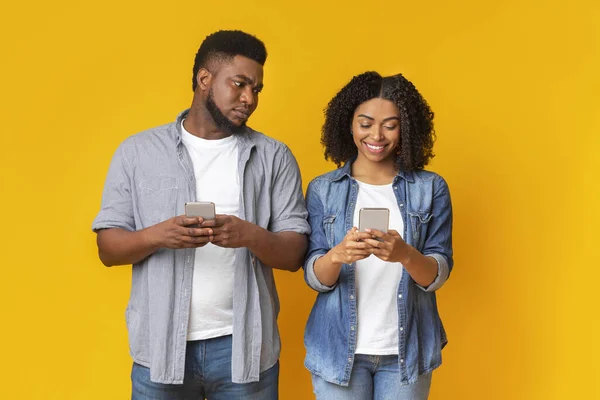 Cemburu orang kulit hitam memata-matai oh pacar telepon, mencoba untuk membaca pesan — Stok Foto