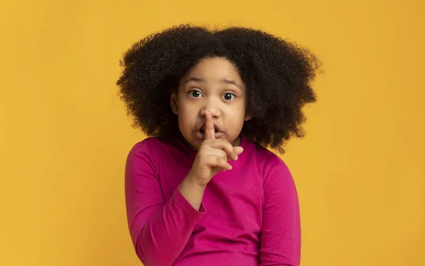 Shh. Vážná malá africká dívka ukazující znamení mlčení, žádající ticho — Stock fotografie