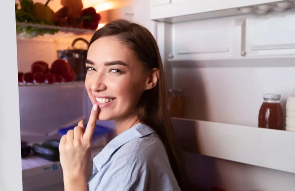 Tricky κορίτσι ανοίγοντας το ψυγείο αργά, gesturing Σσσς στην κάμερα — Φωτογραφία Αρχείου