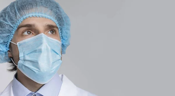 Doktor v lékařské masce a vlasové sítě při pohledu na kopírování prostoru — Stock fotografie