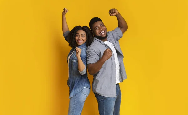 ¡Hurra! Feliz pareja afroamericana celebrando el éxito con los puños levantados — Foto de Stock