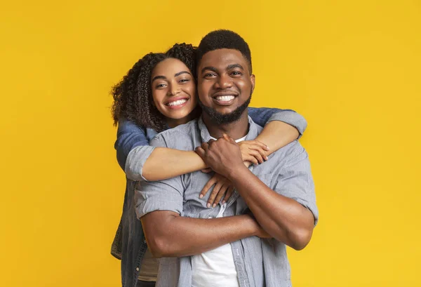 Porträt eines verliebten schwarzen Paares, das sich umarmt und in die Kamera lächelt — Stockfoto