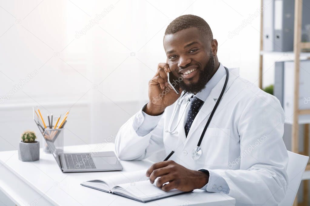 Young doctor talking with patient on smartphone