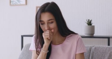 Coronavirus belirtileri. Genç hasta kadın zar zor öksürüyor.