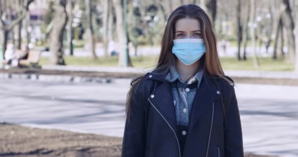 Jonge vrouw draagt gezichtsmasker tegen Covid-19 — Stockvideo