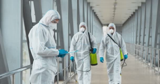 Not defteri olan takım lideri kimyasal deterjanı olan işçilere talimat veriyor. — Stok video