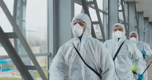 Professionele desinfectoren team draait met chemicaliën naar risicozone — Stockvideo