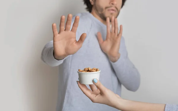 Conceito de alergia alimentar. O homem tem medo de nozes. — Fotografia de Stock