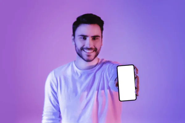 Młody człowiek pokazuje smartfon z pustym ekranem — Zdjęcie stockowe