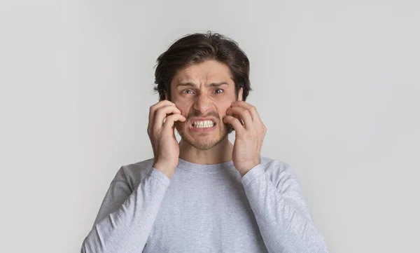 Allergie concept. Millennial man krabt zijn wangen — Stockfoto