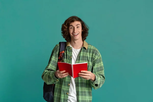 Terug naar school. Happy student met open notebook en rugzak op turquoise achtergrond — Stockfoto
