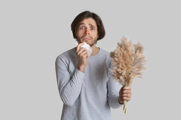 Grappig geschokte man met rode neus, servet en boeket — Stockfoto