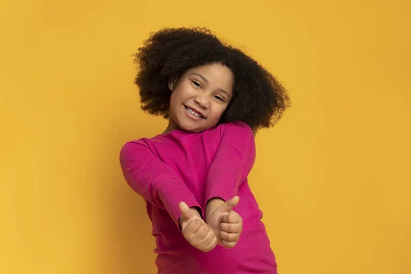 Positivo bonito menina gestando polegares para cima e sorrindo para a câmera — Fotografia de Stock