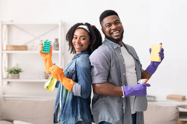 一对快乐的非洲夫妇在一起做家务活时摆出清洁用品的姿势 — 图库照片