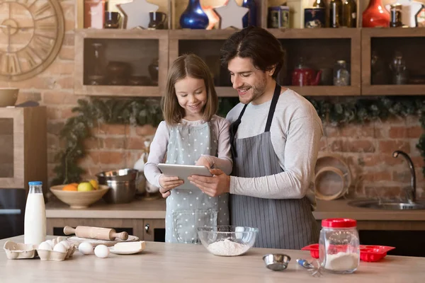 stock image Dad And Daughter Using Digital Tablet Following Recipe To Prepare Dough