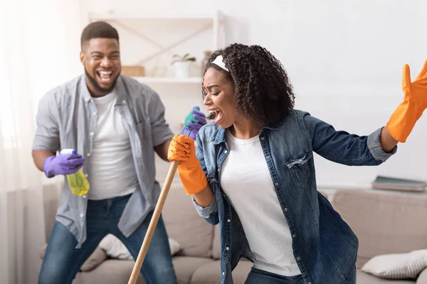 Mutlu Oda Hizmetleri. Neşeli Afrikalı çift evini temizlerken eğleniyor. — Stok fotoğraf