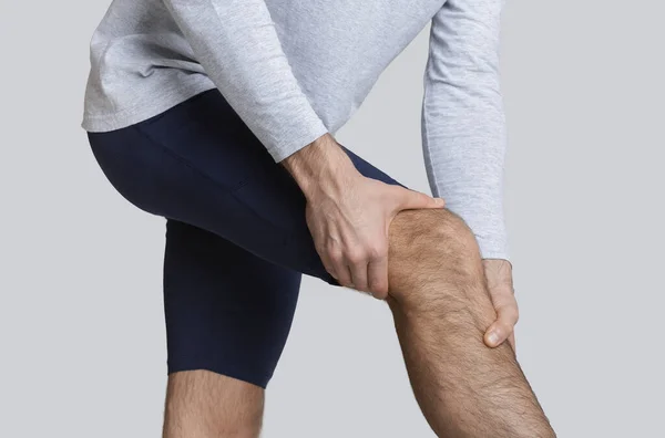 2.运动员膝部疼痛，男子双手紧握着腿 — 图库照片