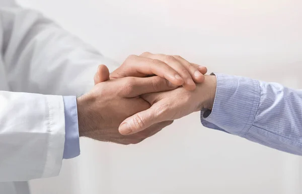 Doctor holding hand of senior woman at medical visit — Stock Photo, Image