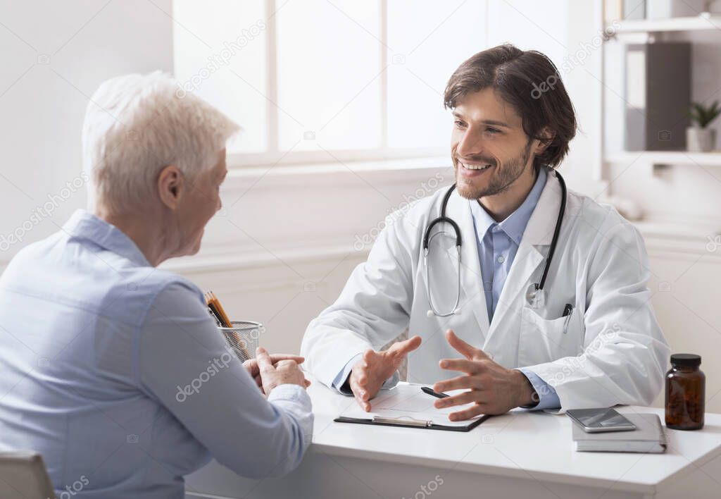 Senior woman consulting with young doctor at his office