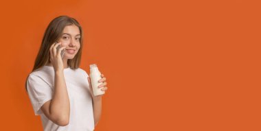 Genç kız elinde taze sıkılmış hindistan cevizi sütüyle detoks içeceği tutuyor.