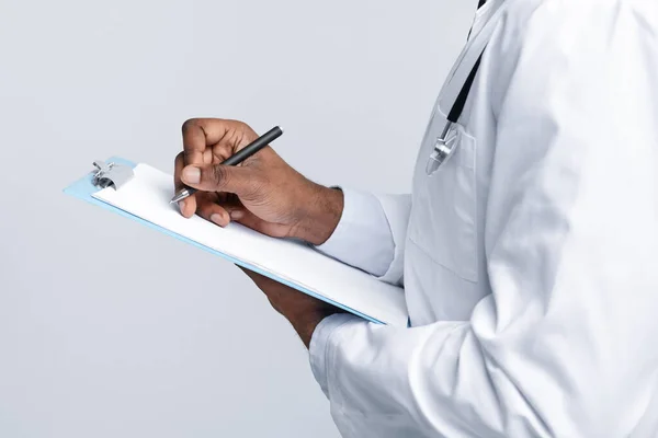 Cropped of african doctor filling medical form — Stock Photo, Image