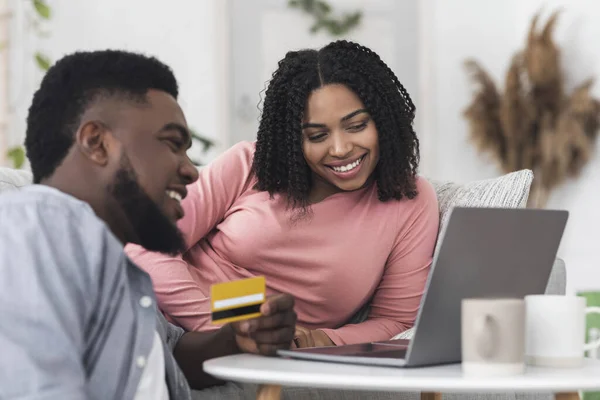 Heureux couple noir à l'aide d'un ordinateur portable et carte de crédit pour les achats en ligne — Photo