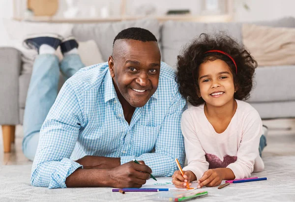 Portret szczęśliwej afroamerykańskiej rodziny rysującej na podłodze w domu. Kreatywne rozrywki kwarantannowe — Zdjęcie stockowe