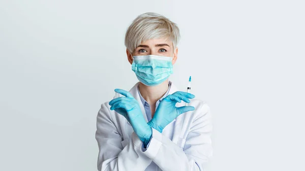 보호용 마스크와 주사기를 쓰고 있는 여자 의사 — 스톡 사진