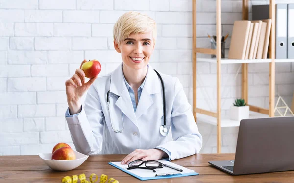 Medico nutrizionista in carica a tavola con mela — Foto Stock