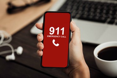 Acil durumda aranacak akıllı telefonu tutan bir işçi.