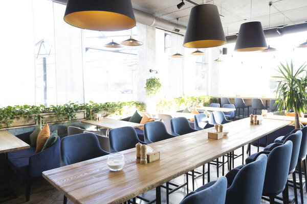 Light modern interior of urban restaurant or cafe with dining places